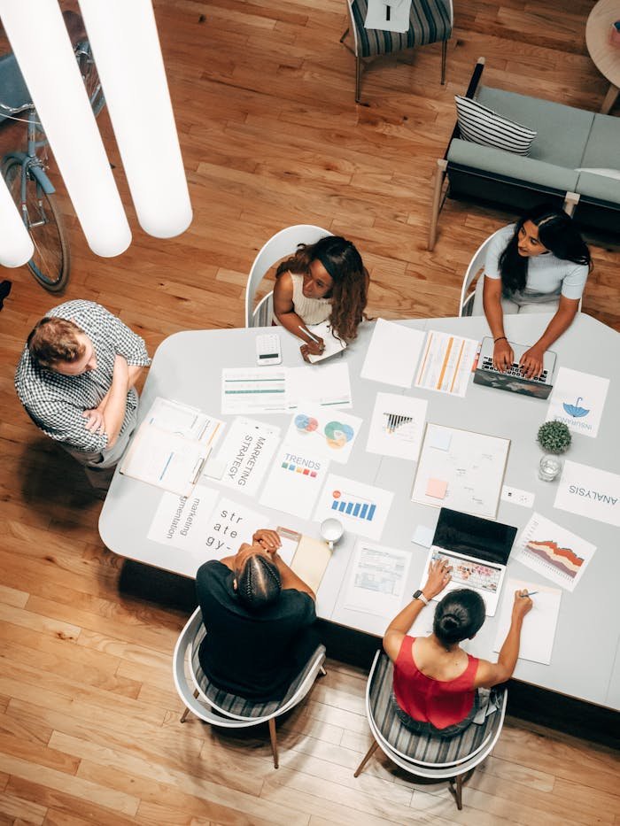 pexels-photo-7688340 High-Angle Shot of Five People Working in the Office